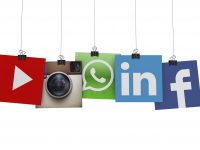 London, United Kingdom- March 15, 2016: Social media  and technology logos printed onto paper hanging on strings. Logos include Facebook, instagram, linkedin and whats app. Social media uses web and mobile technology to connect people